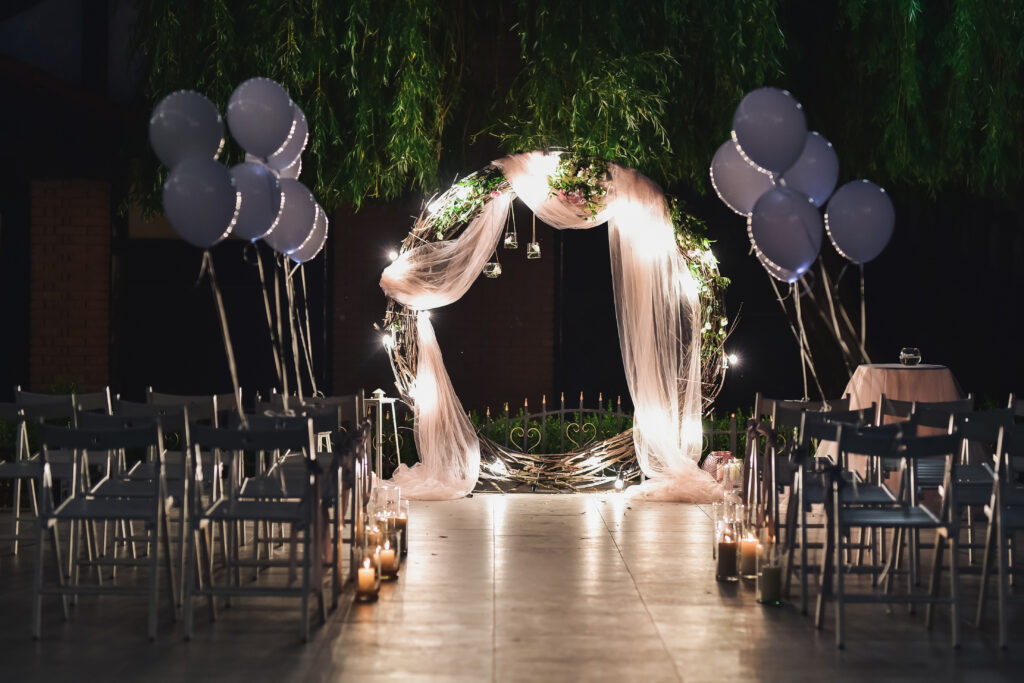 Shine wedding altar for newlyweds stands on the backyard decorated with balloons and greenery